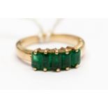 A 18ct gold ring set with five Columbian emeralds,
