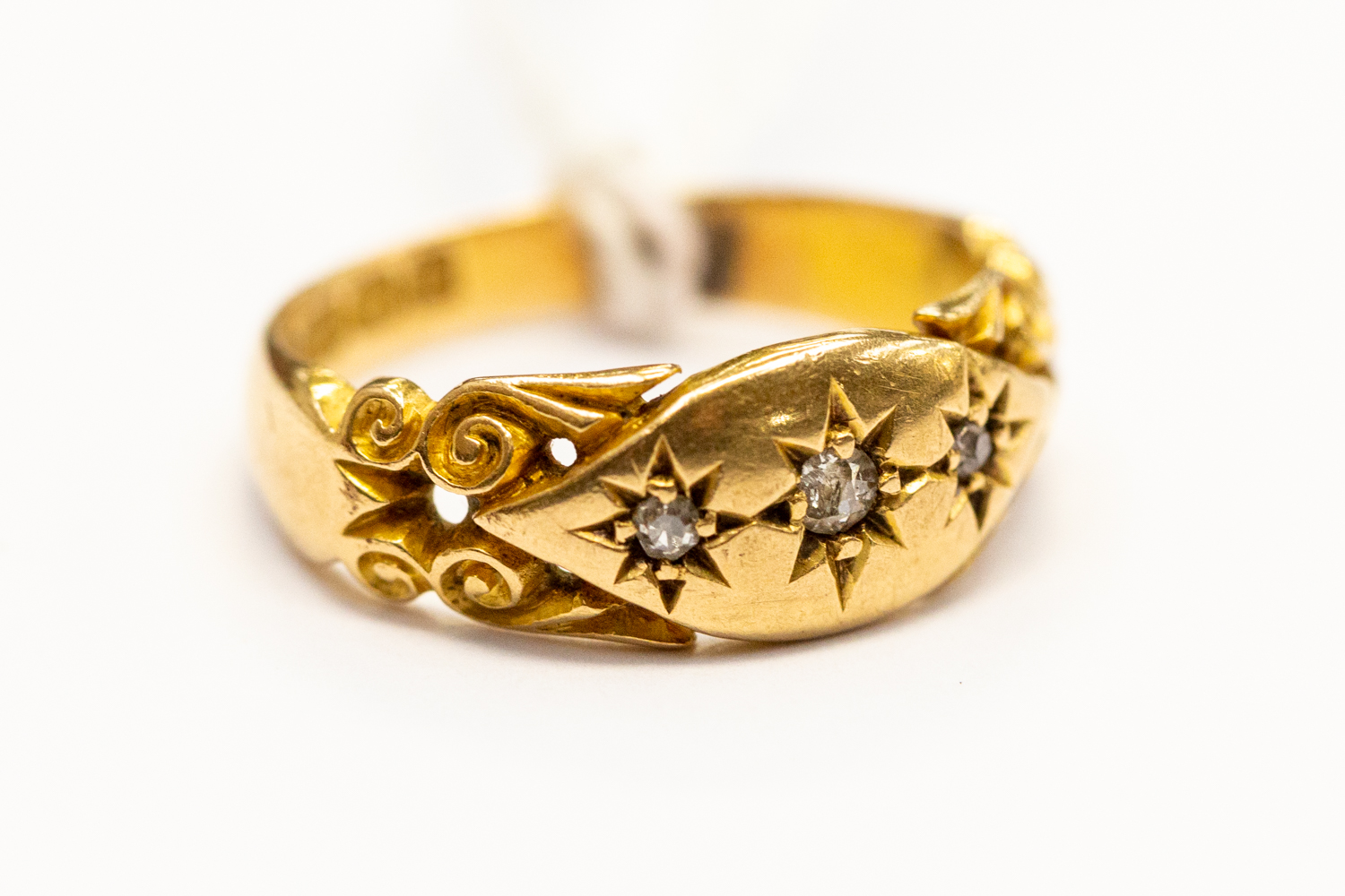 A Victorian diamond set ring, star set with three small diamonds, scroll mount, size J,