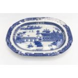 A large 19th Century Earthenware blue and white meat platter decorated with boats and pagoda within
