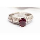 A ruby and diamond set dress ring, the oval claw set ruby approx 0.