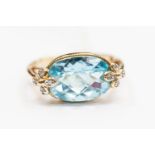 A blue topaz and 9ct gold ring, the oval check board topaz set with diamond daisy set details,