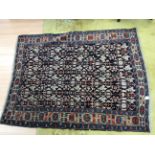 A medium sized woolen aztec design rug with a navy blue and cream ground,