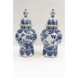 A pair of late 19th Century blue and white octagonal section baluster vases and covers