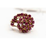 A ruby cluster dress ring, tiered sweeping design set with round cut rubies, set in gilt metal,