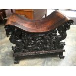 A Chinese hardwood seat with high relief carving of dragons and scrollwork.