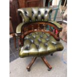 A traditional green leather upholstered deep buttoned swivelling captains chair