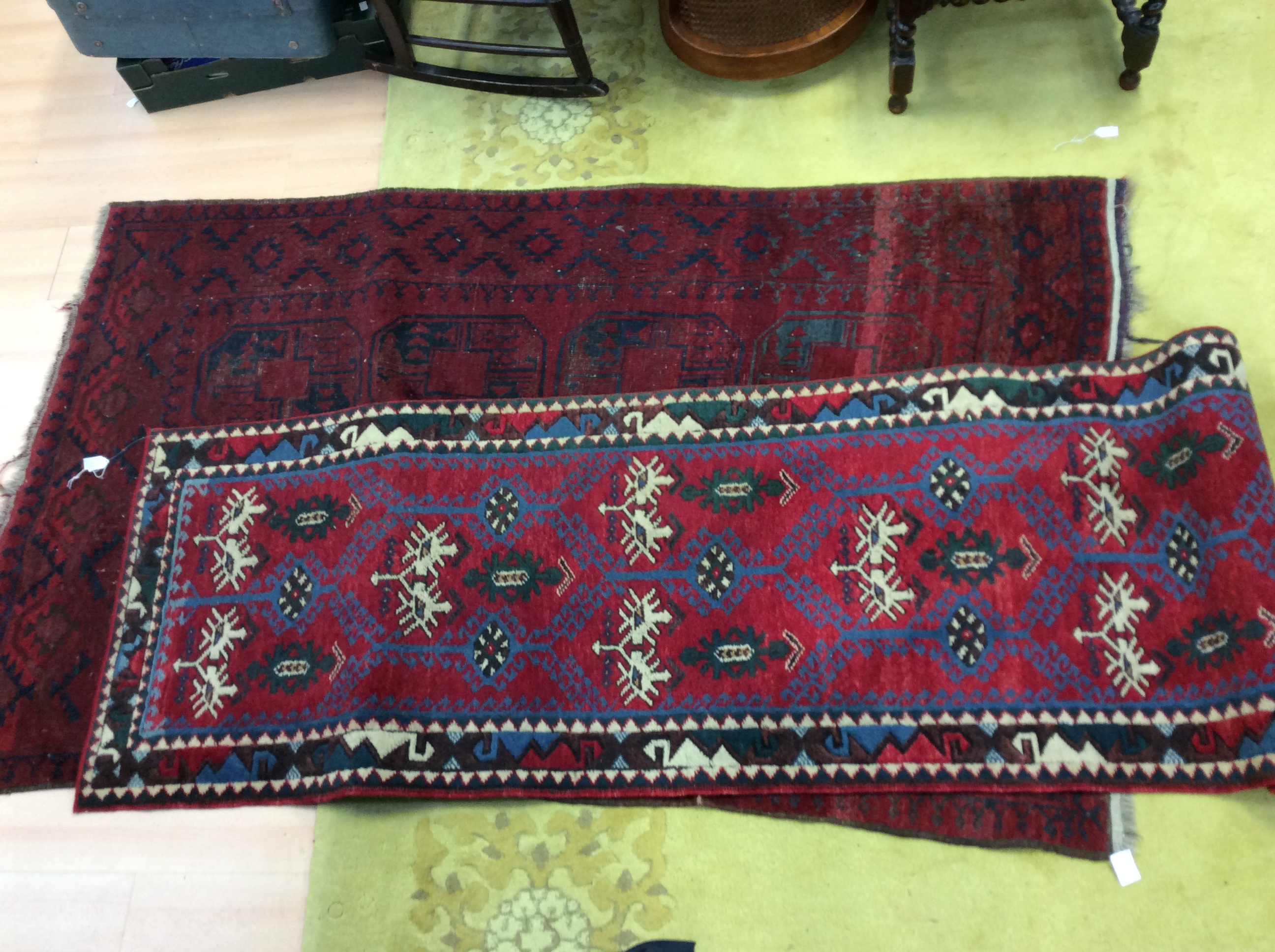 An early 20th Century red ground hand knotted woollen runner rug,