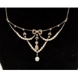An Edwardian garland style diamond and seed pearl set drop fronted necklace,