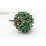 An emerald tiered cluster ring comprising cabochon stones, testing as 9ct gold,
