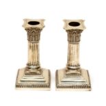 A pair of weighted Corinthian column squat candlesticks, gross weight 28.22/877.9 gms, 5 inches/12.