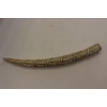 A 19th Century ivory tusk, extensively carved with a continuous spiral of figures,