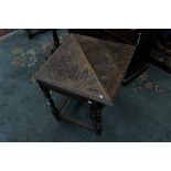 A late Victorian oak carved gate leg table of triangular form