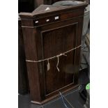 A George III oak hanging corner cupboard.