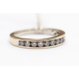 A diamond half set eternity ring, nine brilliant cut diamonds channel set in 18ct white gold,