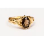 A 9ct gold ring claw set with an oval smoky quartz, size N,