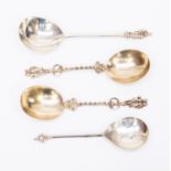 A pair of Victorian silver-gilt serving spoons with twisted ornate stem and figural terminals,