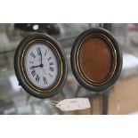 A Cartier grey and gold oval easel photo frame and matching oval timepiece (2)