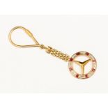 A ruby and diamond Mercedes symbol badge key fob, unmarked 18ct gold, having link chain,