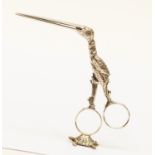 A Continental silver free standing ribbon threader or scissors in the form of stork standing on top