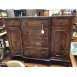 A Geoge III style mahogany breakfront sideboard, having two cupboard doors,