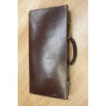 A leather box containing a Masonic belt and various items including rule book, and a tie,