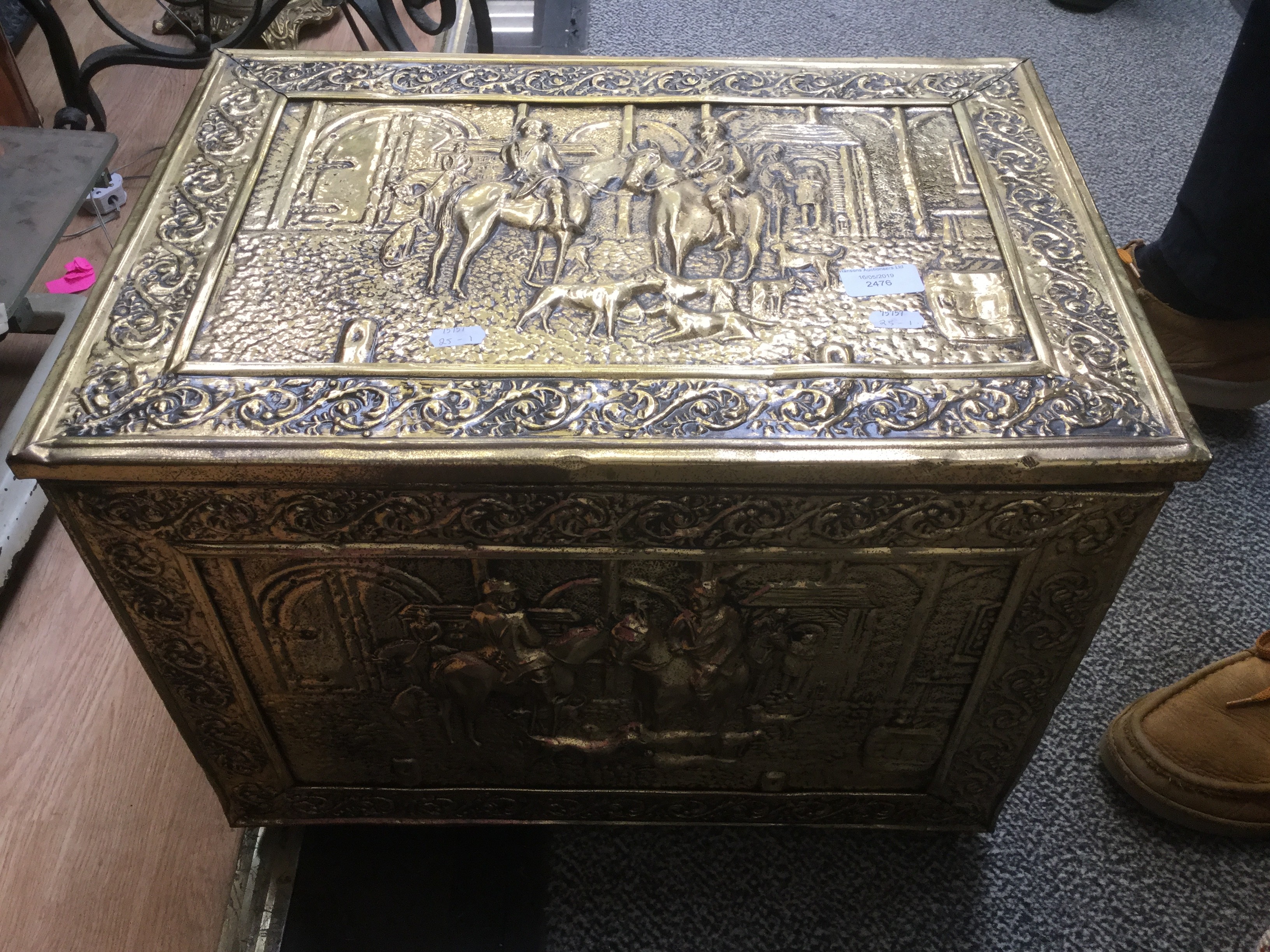 A large Victorian style brass bound rectangular coal skuttle, chased with figures,