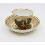 A rare Derby tea cup and saucer, gilded, each with a painted landscape, the cup titled 'Near Toledo,