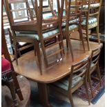 A teak extending dining table with two leaves together with ten dining chairs including two