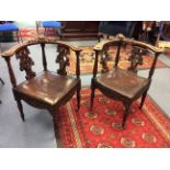 A pair of late 19th Century hand carved corner chairs, mahogany, with carved back splats,