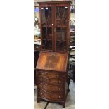 A George III style mahogany bureau bookcase, fitted with two glazed doors enclosing shelves,