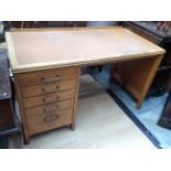 A mid 20th Century oak writing desk, inset top, comprising five drawers,