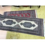 A 20th Century red ground hand knotted woollen rug, with geometric design,