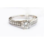 A moissanite and diamond set ring, the claw set round cut moissanite approx 1.