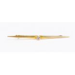 A white sapphire and 15ct gold bar brooch, the central collet set round sapphire weighing approx 0.