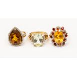 Three 9ct gold stone set dress rings, including a tear drop quartz with diamond surround version,