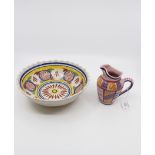 A late 19th Century Quimper bowl with hand painted decoration, together with a similar jug,