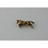 A 9ct yellow gold "jumping horse" brooch, brushed finish with engraved detail, hallmarked Birmingham
