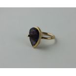 An 18ct. gold and amethyst ring, of modern design, having large pendeloque cut amethyst set within