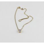 A yellow metal and solitaire diamond pendant choker necklace, bezel set round cut diamond, (
