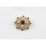 A 9ct. yellow gold, garnet and pearl pendant/brooch, of pierced ovoid form, having cruciform
