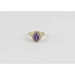 An 18ct. yellow gold, amethyst and diamond ring, set central oval cut amethyst surrounded diamond
