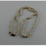 A cultured pearl necklace, the creamy pearls approx. 6mm in diameter, with 14ct. gold clasp set