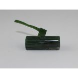 A 20th century dark green jade paperweight, fashioned as an axe in wood log, this with carved bark