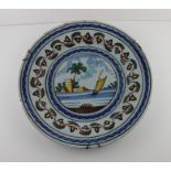 An 18th century Italian tin glaze earthenware Majolica charger, decorated with a sailing vessel with