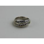 An 18ct. white gold diamond ring, having three slightly serpentine channel set rows of graduated