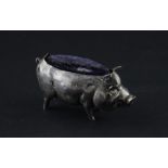 A novelty silver pin cushion fashioned as a standing pot bellied pig, by M Bros., assayed Birmingham