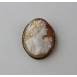 A Victorian oval yellow metal and shell cameo brooch, carved as a profile portrait of Bacchus