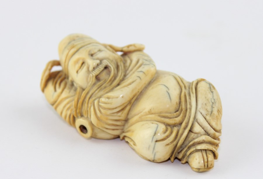 A late 19th century Chinese ivory Lohan, the recognisable figure in recumbent pose, 6.5 cm long
