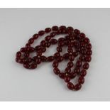 **WITHDRAWN**A string of ovoid cherry amber beads, each bead approx. 15mm   long x12mm diameter,