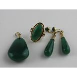 A yellow metal and green jade pendant, ring and earrings en suite, the large pear shaped green